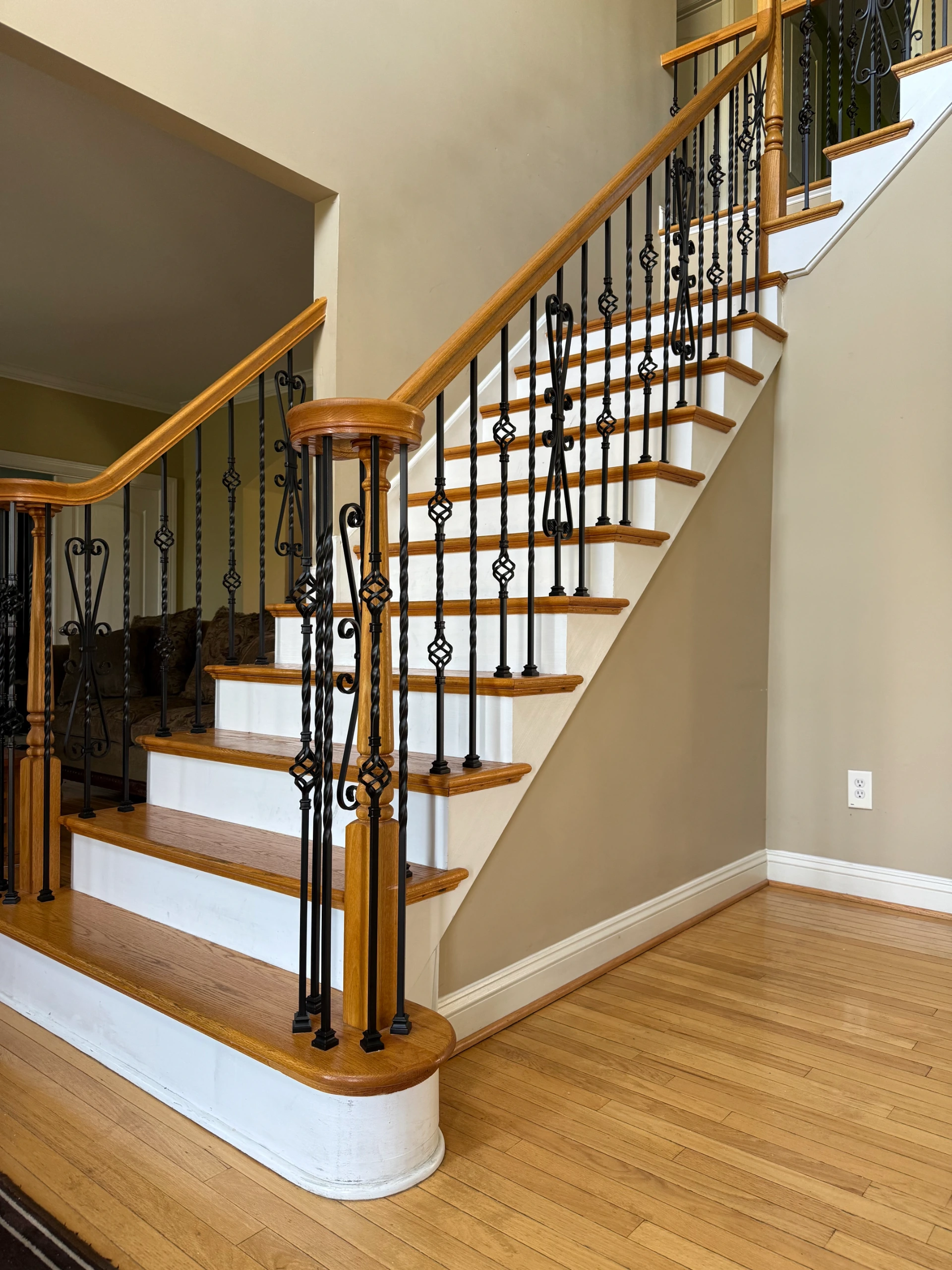 Wood stairs with ornate iron balusters